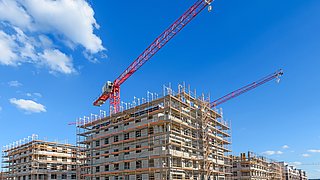 Baustelle für mehrstöckige Wohngebäude mit Kränen im Hintergrund