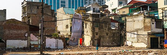 Ruinenhäuser auf Hochbau-Hintergrund Kontrast auf der Minh-Khai-Straße, Hanoi, Vietnam