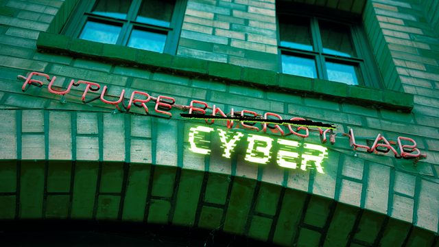 Das Bild zeigt ein Leuchtschild mit der Aufschrift „Future Energy Lab“. Das Wort „Energy“ wurde in einer digitalen Nachbearbeitung durchgestrichen und mit dem Wort „Cyber“ überschrieben.