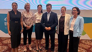 Gruppenfoto von sechs Personen auf dem 4. Deutsch-Indischen Umweltforum am 1. September 2026. Von links: Eine Frau in dunklem Anzug, dena-Geschäftsführerin Kristina Haverkamp, eine Frau in weißem Oberteil, Bundesumweltminister Carsten Schneider (Mitte), eine Frau in hellem Blazer und eine Frau in blauem Blazer. Im Hintergrund ist eine Leinwand mit dem Datum und dem Logo des Forums zu sehen.