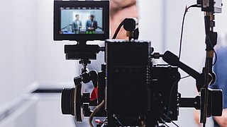 Interviewsituation durch das Display einer Kamera betrachtet