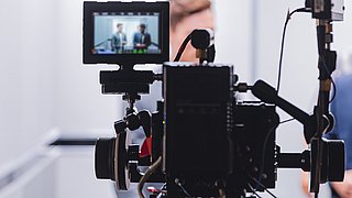 Interviewsituation durch das Display einer Kamera betrachtet