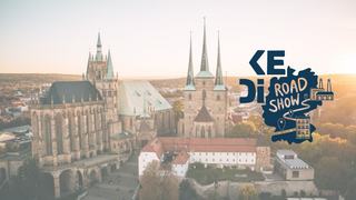 im Hintergrund sieht man eine Aufnahme aus Vogelperspektive aus den Domplatz und die Altstadt in Erfurt.