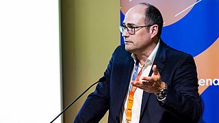 Nahaufnahme von Alexander Renner, der eine Rede am Podium hält.