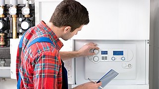 Techniker, der einen Wasserboiler wartet.