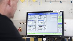 Ein Mitarbeiter überwacht an einem Terminal den Malzvorgang in einer Mälzerei.