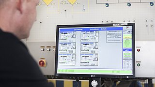 Ein Mitarbeiter überwacht an einem Terminal den Malzvorgang in einer Mälzerei.