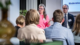 Katalin Gennburg (Die Linke) und Dominik Räder (ZVEH) diskutieren auf dem Podium. Blick aus der Zuschauerperspektive. 