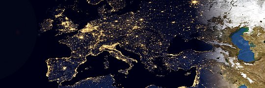Satellitenaufnahme von Europa bei Nacht mit erleuchteten Städten und dem Übergang von Dunkelheit zu Tag in Richtung Osten.