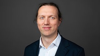 Porträtfoto Uwe Bigalke, Teamleiter im Bereich Klimaneutrale Gebäude vor einem neutralen Hintergrund