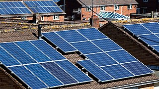 Dach mit mehreren Solarpanelen auf einem Wohnhaus in einem Wohngebiet