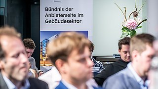 Blick auf das Roll-up mit der Aufschrift "Bündnis der Anbieterseite im Gebäudesektor" 