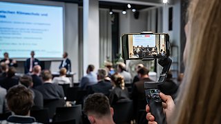 Blick auf das Podium aus der Perpsektive des Publikums. 