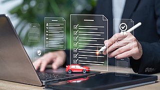 Eine Person sitzt mit einem Stift und Miniaturauto vor einem Laptop, es werden stilisierte Checklisten eingeblendet