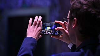 Ein Teilnehmer macht ein Foto mit dem Handy.