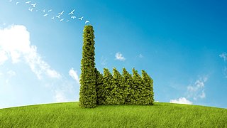 Eine grüne Fabrik aus Pflanzen mit einem hohen Schornstein und fünf Dächern, umgeben von einer grünen Wiese und fliegenden Vögeln im Himmel.