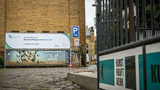 Der Eingang zur Eventlocation mit Banner ist zu sehen.