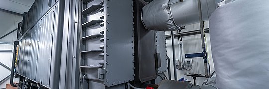 Industrieanlage mit mehreren großen Metallrohren und isolierten Leitungen