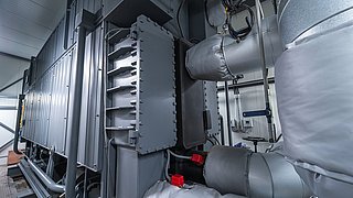 Industrieanlage mit mehreren großen Metallrohren und isolierten Leitungen