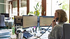 Eine Frau spricht am Telefon in einem Büro.