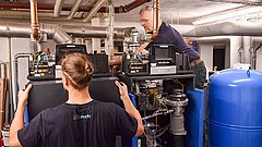 Monteure, welche die technische Lösung zur Heizungsoptimierung installieren.