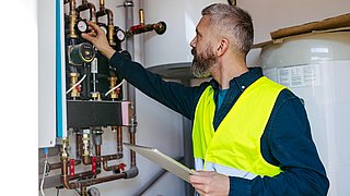 Technician inspecting circulation pumps for underfloor heating system.