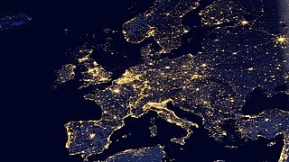 Nachtaufnahme von Europa mit leuchtenden Städten und Straßen, die ein Netzwerk aus Lichtpunkten bilden.