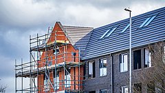 Ein Mehrfamiliengebäude von einem Baugerüst umhüllt