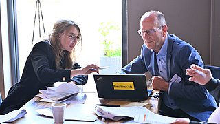Zwei Personen diskutieren am Gruppentisch beim Workshop.