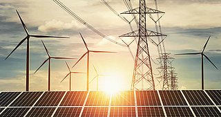 Solarpanel, Windräder und  Hochspannungsleitungen vor Sonnenuntergang 
