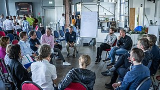 Personengruppe sitzt im Kreis bei einem Workshop