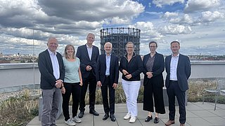 Auf dem Bild sind die Jurymitglieder des dena Energy Awards zu sehen, im Hintergrund die Stadt Berlin.