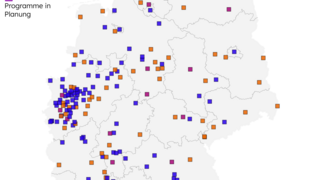 Karte Deutschlands mit farbigen Punkten, die Städte darstellen. Orange für Städte mit Förderprogrammen, blau für Städte ohne, lila für Städte in Planung. 104 Städte fördern Begrünung.
