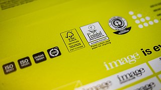 Gelbe Verpackung mit verschiedenen Zertifizierungslogos: FSC, EU Ecolabel und Recycling-Symbol. Darunter steht 'image is everything'.