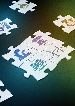 Puzzleteile auf denen verschiedene Energiesymbole gedruckt sind.