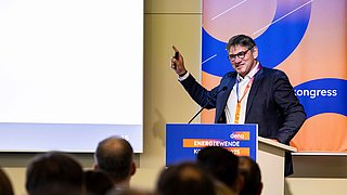 Nahaufnahme von Andreas Holm auf dem Podium bei der Präsentation seiner Folien.