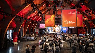 SET Tech Festival, ein großer Raum mit Menschen, die an Tischen sitzen und sich unterhalten.
