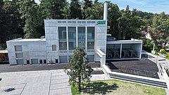 Biomasseheizwerk mit Parkplatz und Container für die Lagerung des Altholzes auf dem Firmengelände am Standort Bruckmühl.