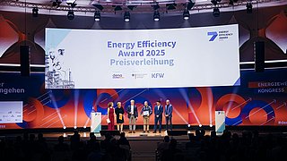 Bühnenaufnahme der Energy Efficiency Award 2025 Preisverleihung mit mehreren Personen auf der Bühne vor einem großen Banner mit dem Text ‚Energy Efficiency Award 2025 Preisverleihung‘.