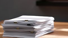 Stack,Of,Blank,Paper,With,Binder,Clips,On,Wooden,Table