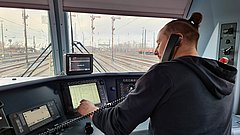 Ein Lokführer im Führerstand einer Lokomotive.