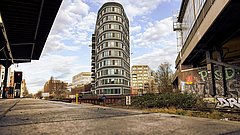 Moderner EUREF-Gebäudekomplex neben einer Bahnstrecke mit Graffiti an den Wänden.