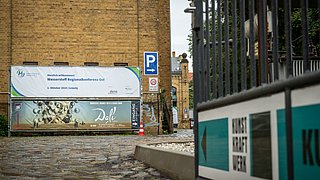 Der Eingang zur Eventlocation mit Banner ist zu sehen.