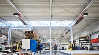 Halle, die mit einer Multi-Energie-IR-Hallenheizung beheizt wird, in der auch die Hallenbeleuchtung integriert ist.