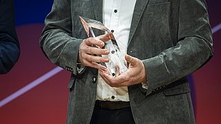 Eine Trophäe des Energy Efficiency Awards 2025, gehalten von einem Preisträger
