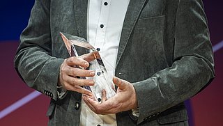 Eine Trophäe des Energy Efficiency Awards 2025, gehalten von einem Preisträger