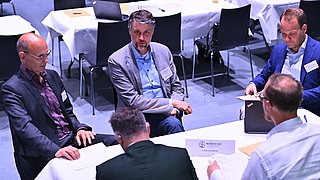 Menschen diskutieren an einem Gruppentisch.