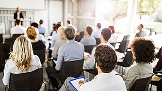 Back view of large group of entrepreneurs on a seminar.
