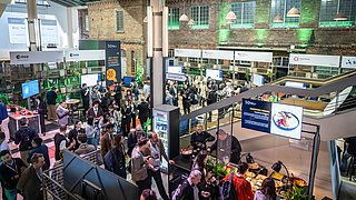 Blick auf eine Menschenmenge die sich auf dem SET Tech Festival um verschiedene Stände scharrt.
