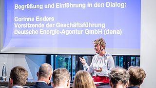 Corinna Enders (dena) hält das Begrüßungswort auf dem Podium